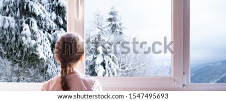 sitting girl at the window. And outside the window is winter.