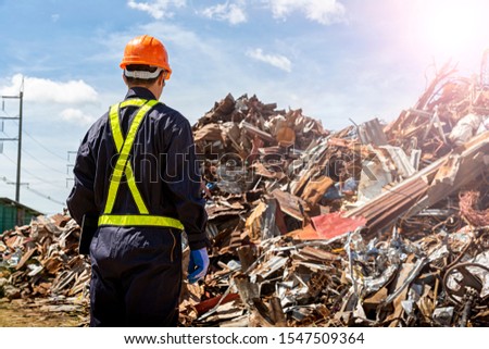 The engineers in the recycling plant that are carrying the tablet. Looking for recycled materials with paper, metal, glass laid in the factory. Royalty-Free Stock Photo #1547509364