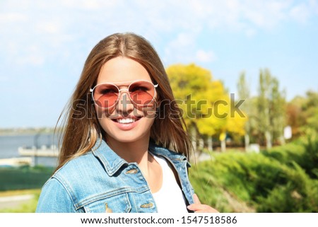 Young woman wearing stylish sunglasses in park