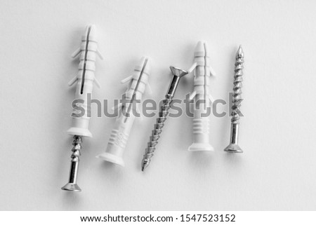 Three dowels with screws lying on a white background. Plastic anchor for repair.