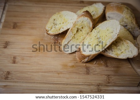 Tasty garlic bread, baguette on kitchen board