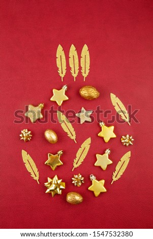Christmas decoration with golden ornaments in the shape of decorating xmas bauble over the red background. Season greeting card, party invitation, christmas celebration concept
