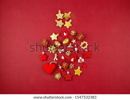 Christmas decoration with golden ornaments in the shape of decorating xmas bauble over the red background. Season greeting card, party invitation, christmas celebration concept