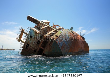 Stern of wrecked cargo ship at cape tarhankut, Crimea. The weather is clear, there are vawes at the sea.  Royalty-Free Stock Photo #1547580197