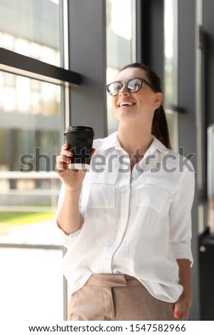 Portrait of female business trainer with cup of coffee indoors