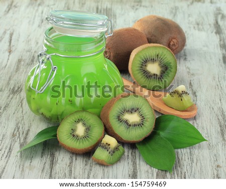Jar of jam kiwi on wooden table close-up