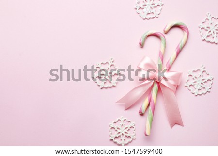 Creative minimal christmas art. The pattern is made with Christmas candies, bow, snowflake on a bright pink background. The apartment was lying. Space for copy. Minimum composition.
