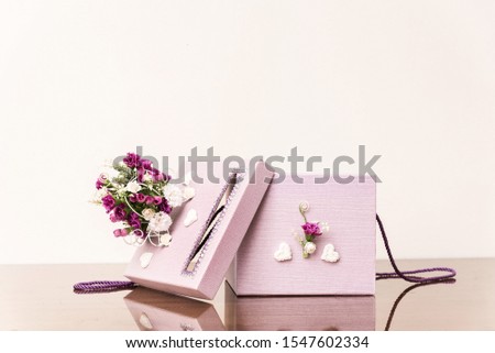Open box decorated with flowers on wooden table in white background. Amazing gift for weddings, birthdays or other ceremony. Picture with copy space