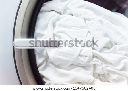 A washing machine and a pile of dirty towels and  bedclothes inside. Billboard, wallpaper picture, copy space
