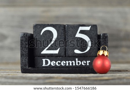 Wooden retro calendar with the date of Christmas and red Christmas ball 