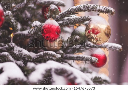 Outdoors image of christmas tree branch with balls and festive lights decorated on a town square. Clear glass and lights Christmas decoration. New Year decoration. Christmas and new year concept.