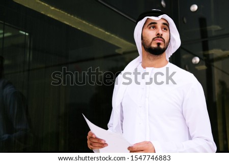 Arab businessman holding a paper ideal for business deal contract or corporate planning. Copy space, mock up Royalty-Free Stock Photo #1547746883