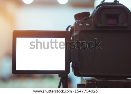 Video or professional digital dslr with blank lcd on tripod for camera recording taking photograph in production house or convention hall in live streaming event, media meeting  broadcast equipment.