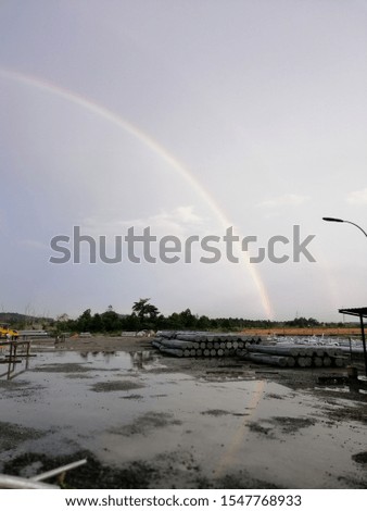 A reflection of rainbow on the surface of the water flood at the construction site. Picture may be have a little bit noise and soft focus. 