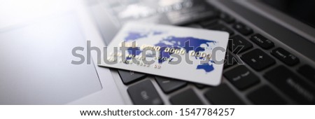 White plastic credit card lie on black laptop keyboard background. Online distance shopping concept