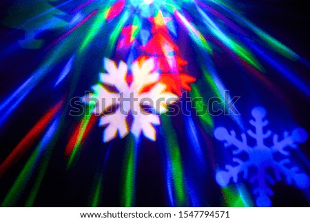 rays of light on a black background. Colored snowflakes and christmas trees