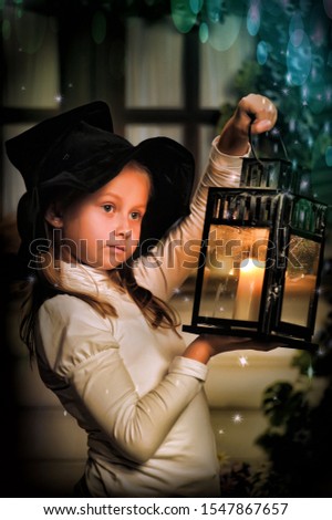 Portrait of a little girl looking at the candle in the lantern