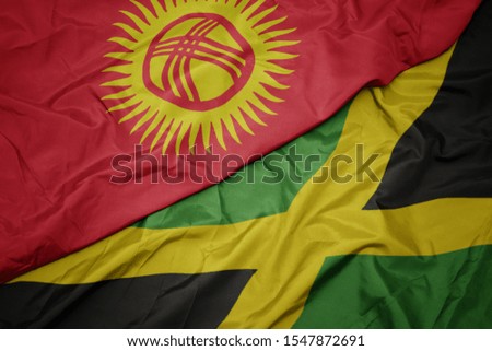 waving colorful flag of jamaica and national flag of kyrgyzstan. macro
