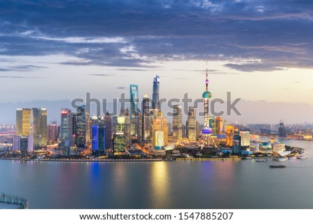 shanghai skyline in nightfall, futuristic pudong financial center and beautiful huangpu river, China.
