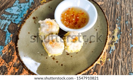 Dimsum or dumplings called siomay with sweet and sour  spicy sauce.