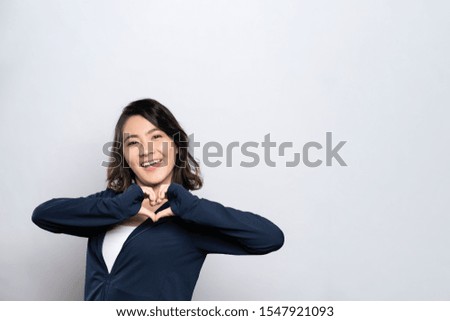 Portrait of a healthy woman in love making love symbol isolated over white background