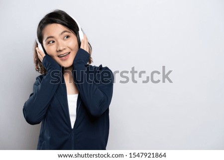 Portrait of a healthy woman with headphones and listening to music isolated on white background