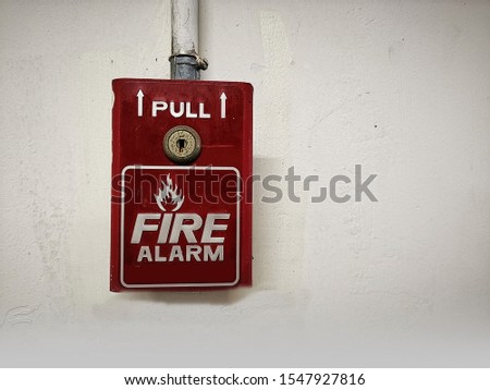 Red fire alarm switch box on cement wall for warning and security system