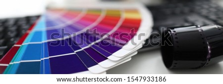 Color palette camera and keyboard are on white table in office. Correct color matching concept