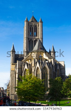 Vertical picture of the facade of Saint Nicholas' Church (Sint-Niklaaskerk) in a sunny day with green trees of Emile Braunplein at the foreground, in Ghent, Belgium, Europe