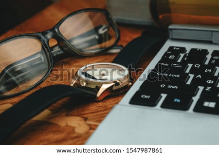 Business concept, on the table are the clock laptop keyboard and glasses