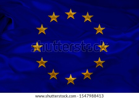 close-up photo of beautiful colored stylized European Union flag, symbol of united Europe on textured fabric, concept of tourism, emigration, economy and politics, close-up
