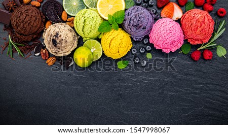 ice cream flavor ball blueberry ,lime ,pistachio ,almond ,orange ,chocolate and vanilla set up on dark stone background . Summer and Sweet menu concept.
