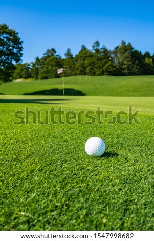 View of Golf Course with Golf Ball. Golf course with a rich green turf beautiful scenery.
