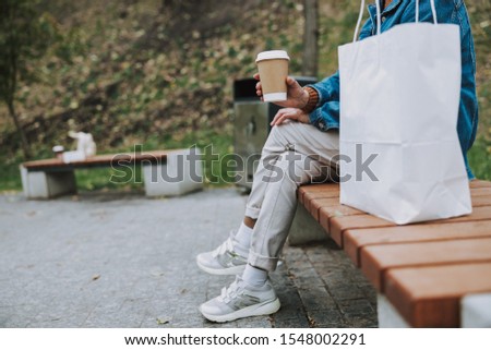 Cropped photo of old lady sitting on bench outdoors stock photo