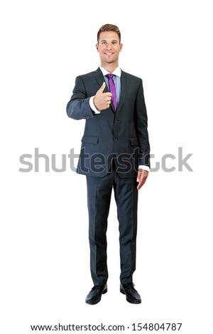 full length picture of a young business man showing thumb up and holding the other hand in his pocket, while smiling to the camera on white background 