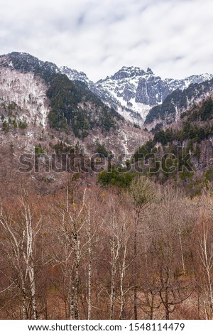 Mountain peak vertical view with snow in Okuhida Shinhotaka Ropeway in Gifu Prefecture, Japan park with cloudy sky on spring day