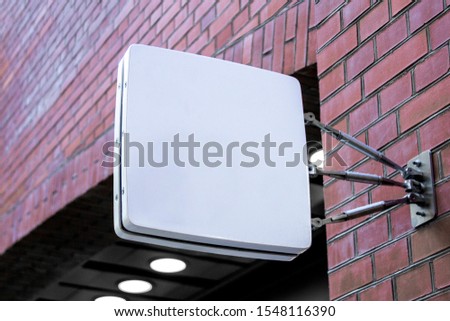 Mockup of the blank white modern square hanging logo signage with rounded corners on the brick wall or facade