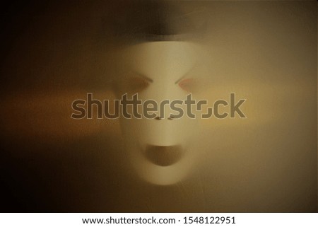 Mask terrifies behind a cloth