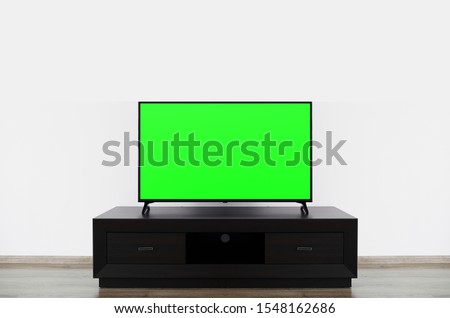 Close up of LCD 4K television with blank screen standinding on TV stand . Mock up Smart TV