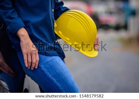 Female Engineer holding hardhat safety Standing outdoor work place 