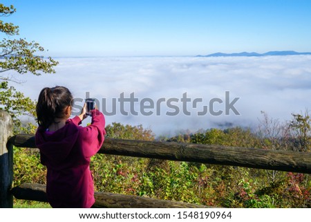 Girl taking a photo overlooking the grand canyon of Arkansas along scenic byway 7