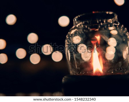 red fire in glass lantern with bokeh lights background , in dark blue night