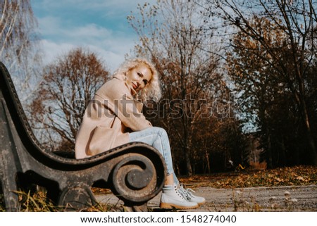 Middle-aged Woman sitting on the bench at autumn city park