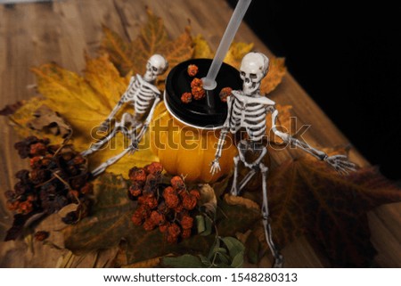                skeleton on the background of a glass in the shape of a pumpkin                
