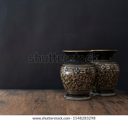 old vases in a wood table in black background Royalty-Free Stock Photo #1548283298