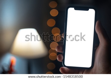 Close-up of male hand holding smartphone with mockup.