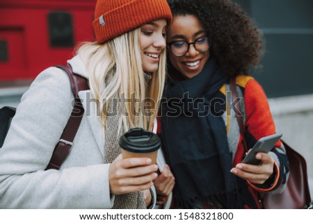 Cheerful women looking at mobile phone display stock photo