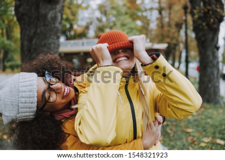 Cheerful women in yellow raincoat walking outdoors stock photo