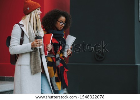 Glad young women standing after lecture near university stock photo