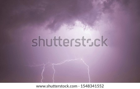 night landscape with black sky illuminated by lightning discharge during thunderstorms, real windy and rainy weather